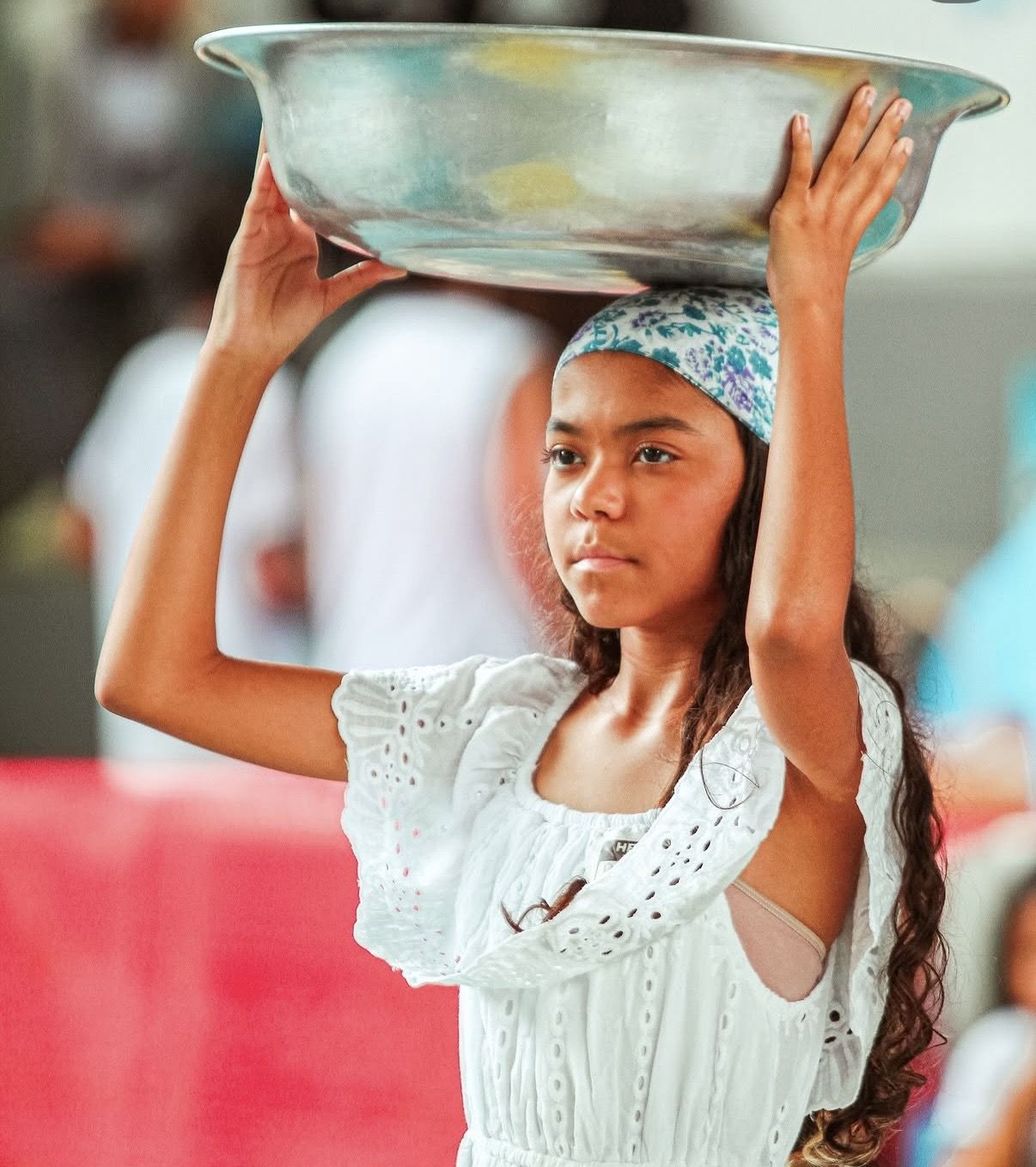 Aluna com bacia na cabeça em apresentação cultural