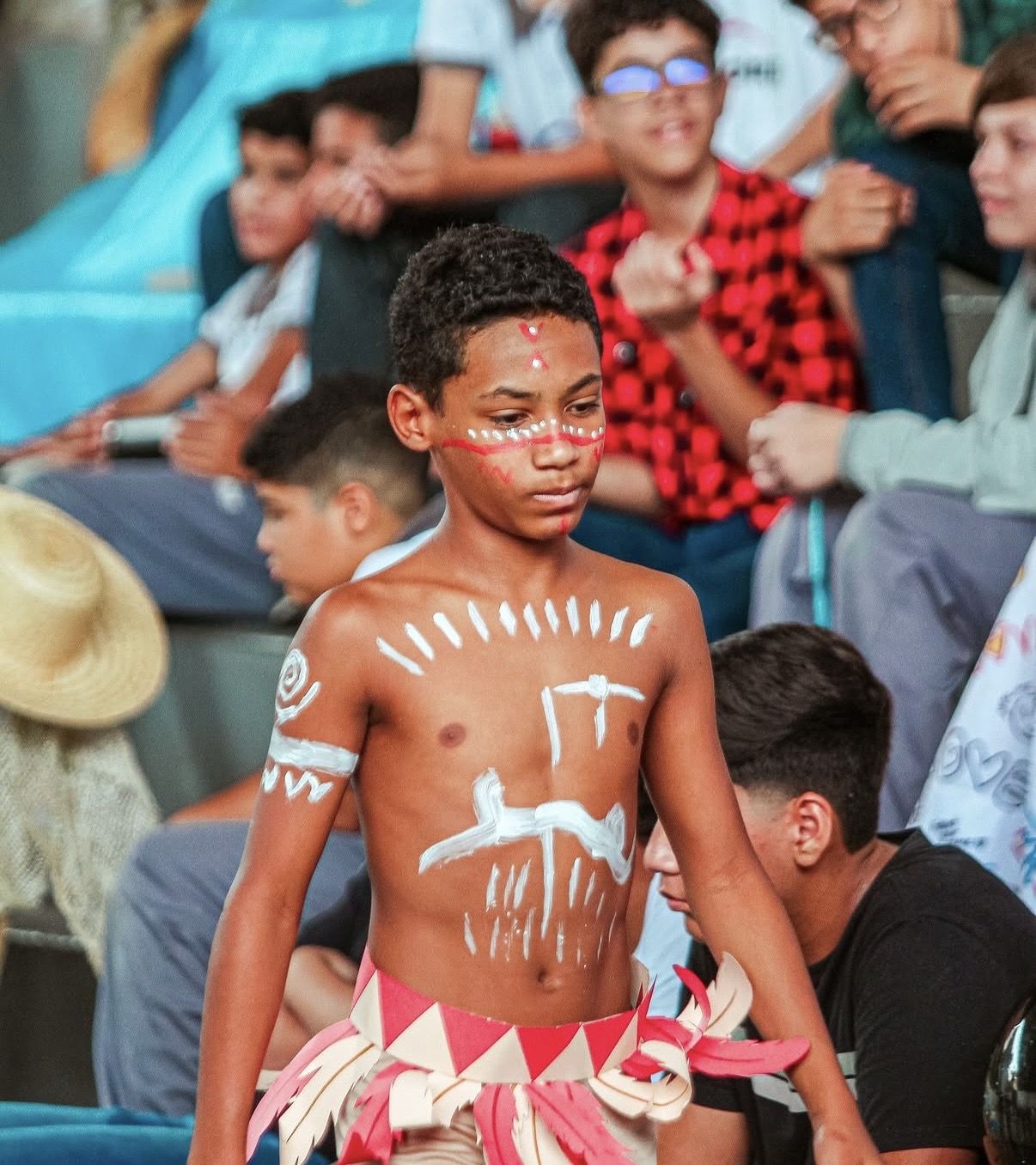 Aluno com pintura corporal em apresentação cultural