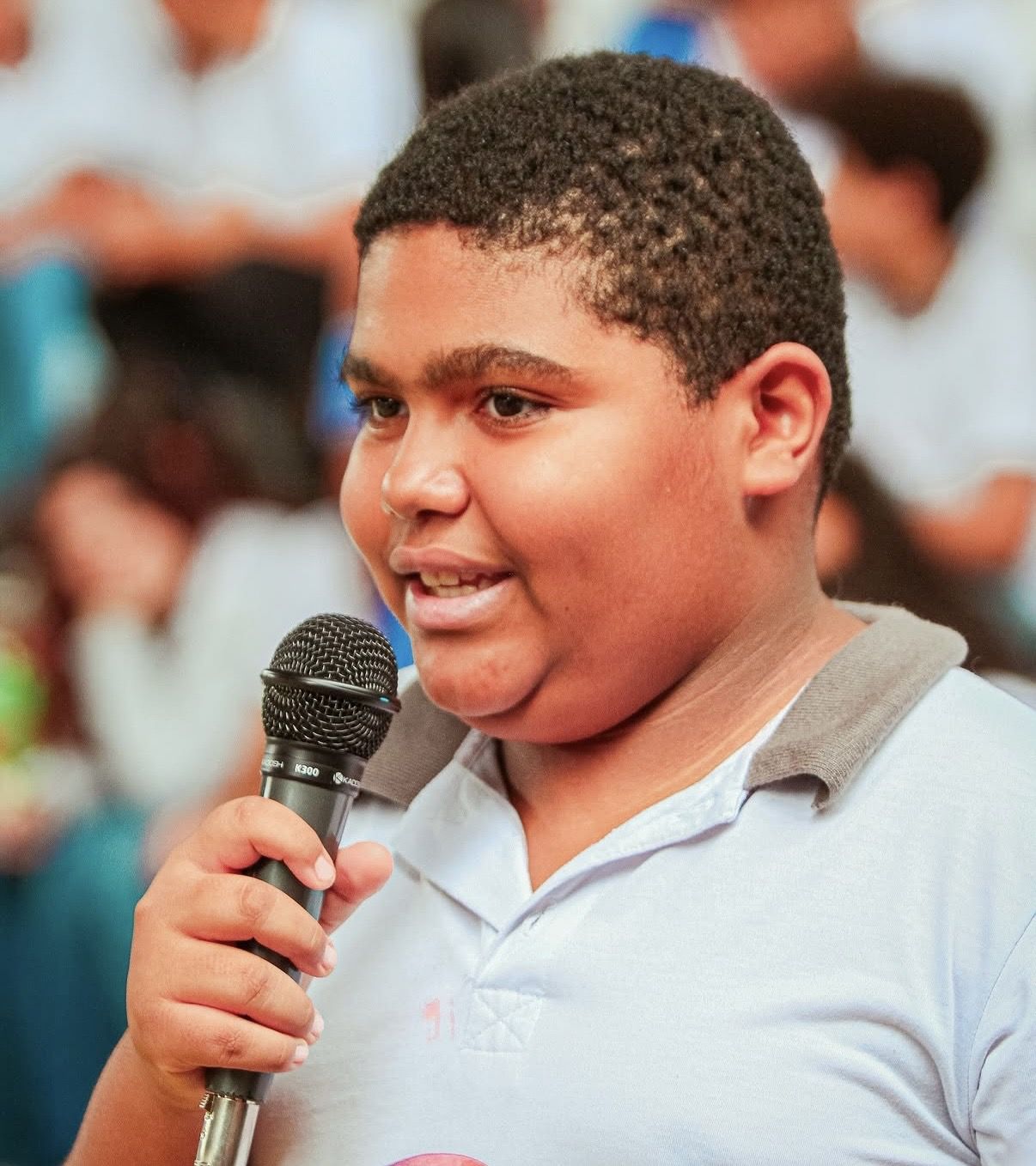 Aluno falando ao microfone em evento da escola
